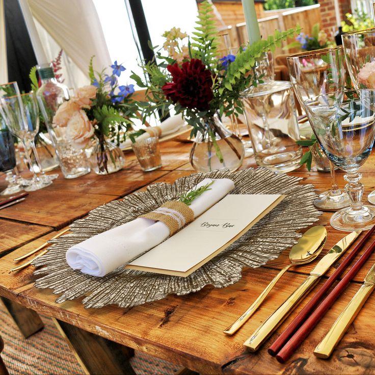 a wooden table topped with lots of place settings