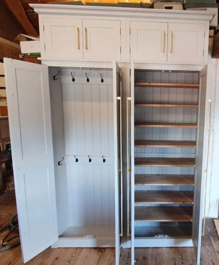 an empty white cabinet with shelves and drawers