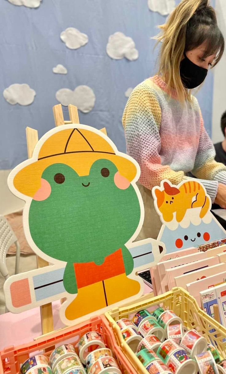 a woman wearing a face mask standing in front of an assortment of items