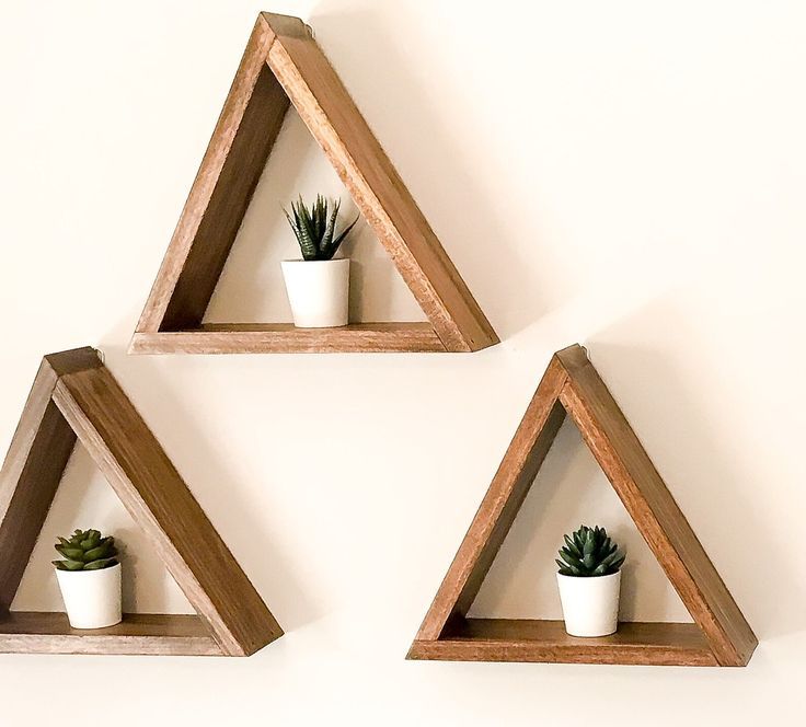 three wooden triangle shelves with plants on them