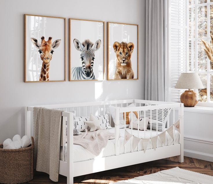 a baby's room with three pictures on the wall and a crib next to it