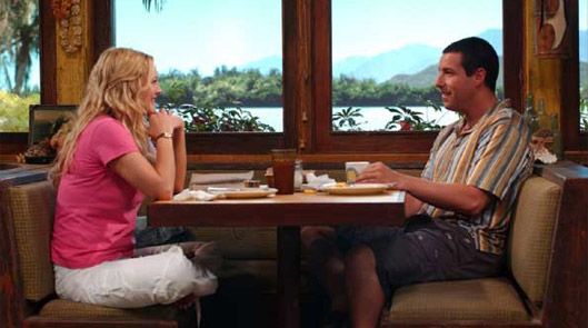 a man and woman sitting at a table with food in front of them, talking to each other