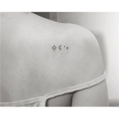 the back of a woman's shoulder with three crosses and two stars on it