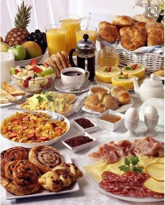 a table filled with lots of different types of breakfast foods and condiments on it