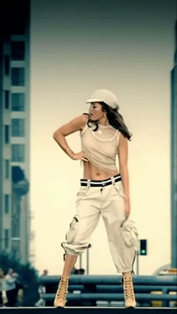 a woman standing on top of a street next to tall buildings