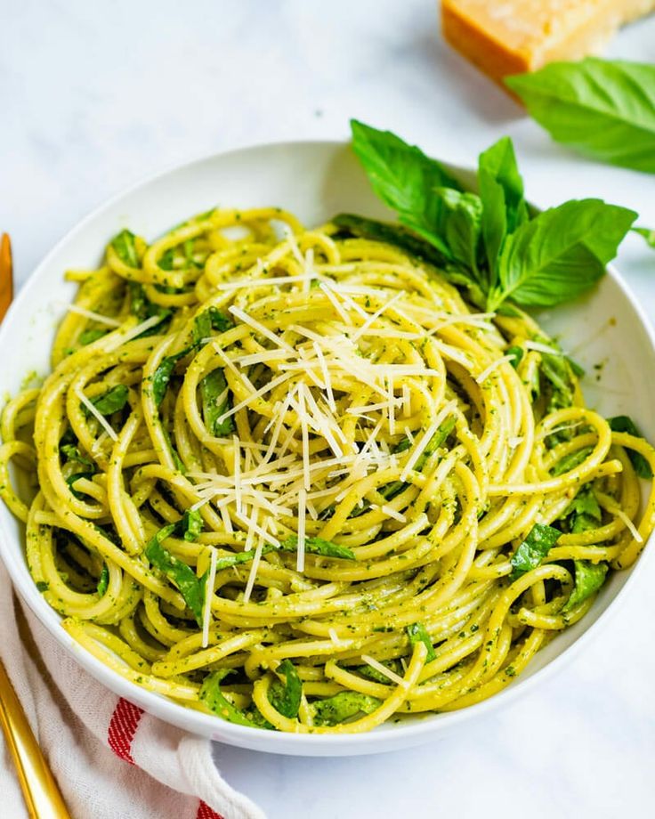 a white bowl filled with pasta and pesto