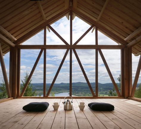 a room with wooden flooring and large windows overlooking the mountains in front of it