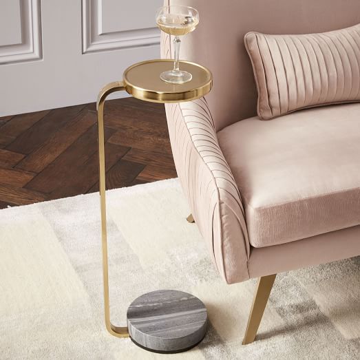 a living room with a chair, table and wine glass on the floor next to it