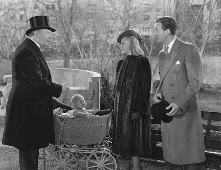 an old black and white photo of three people with a baby in a stroller