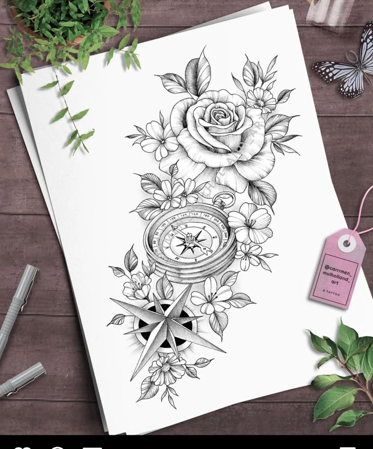 a card with flowers on it next to some pens and scissors, which are sitting on top of a wooden table