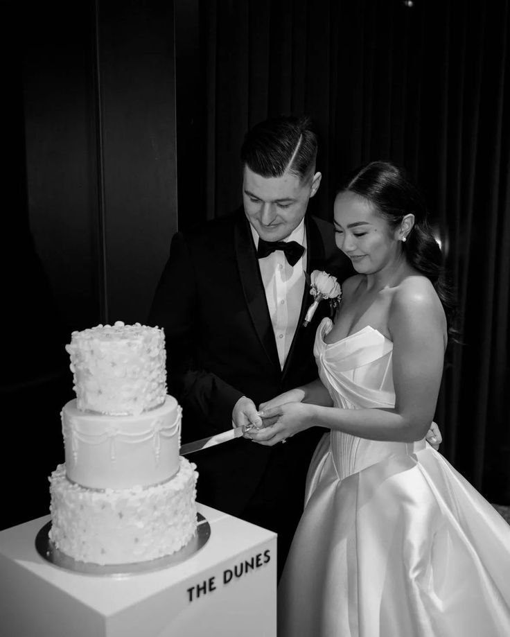 a bride and groom cutting their wedding cake