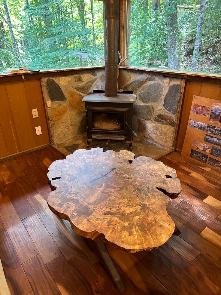 a wooden table sitting in front of a wood stove