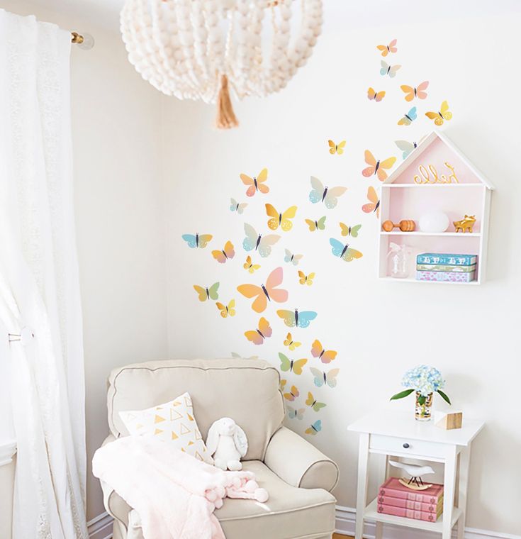 a baby's room decorated in pastel colors with butterflies on the wall and a white rocking chair