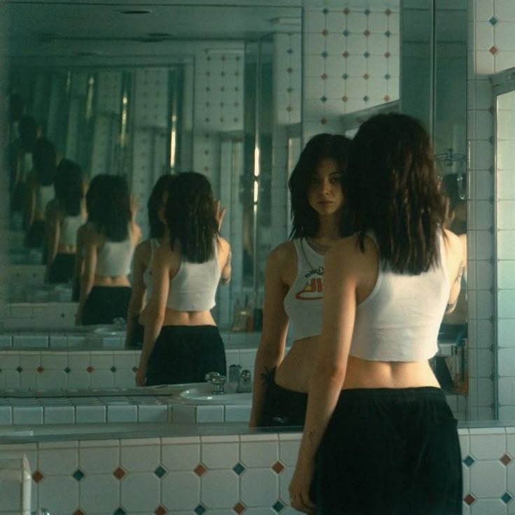 two women standing in front of a mirror with the caption why would i show you the versions of myself that don't even existt