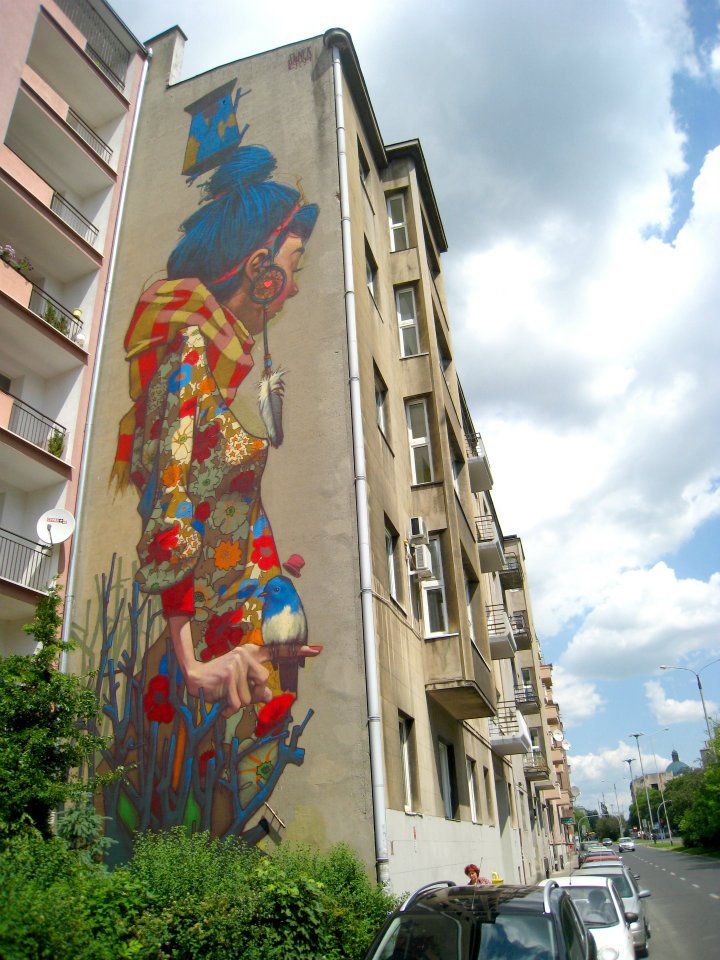 a large mural on the side of a building next to a car parked in front of it