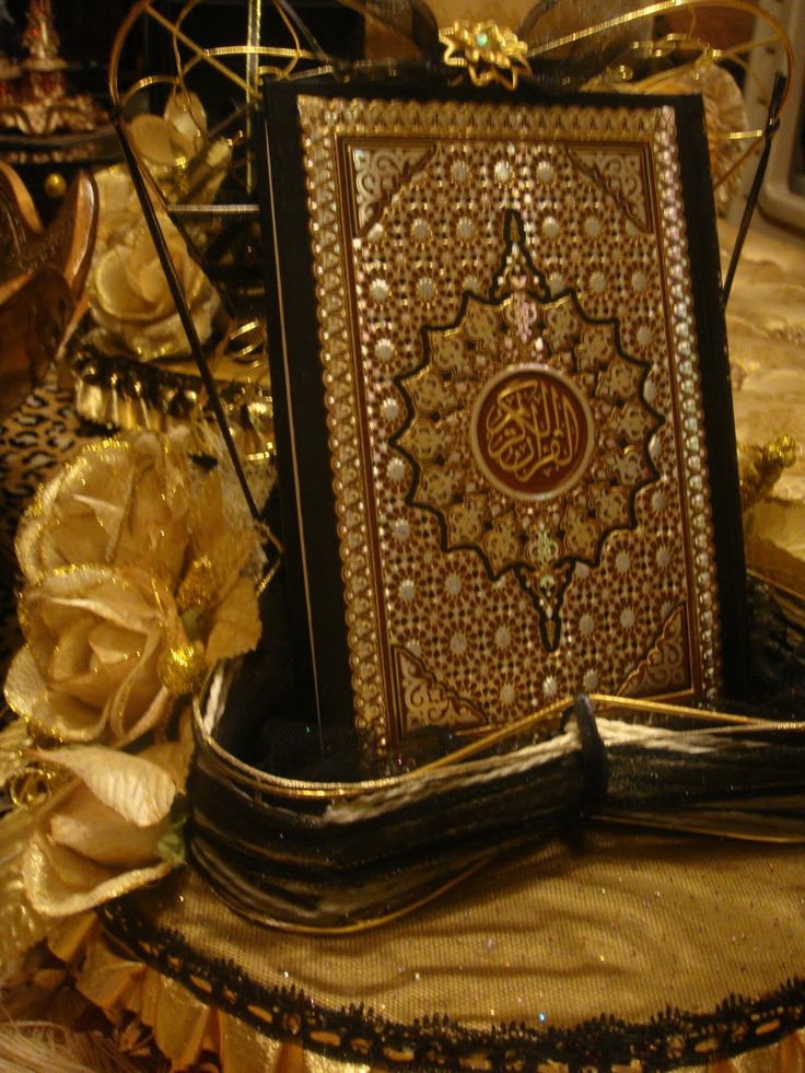 an intricately decorated book on a table with flowers and other decorations in the background