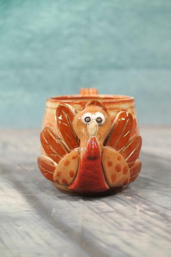 a ceramic turkey cup sitting on top of a wooden table