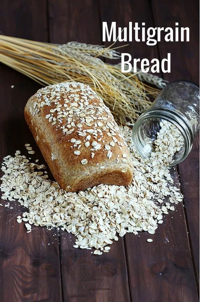 a loaf of bread sitting on top of a wooden table next to some oats