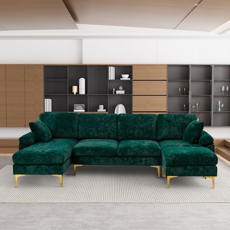 a large green couch sitting in front of a wooden book shelf on top of a carpeted floor