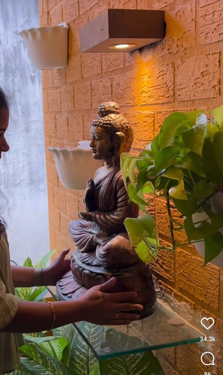 a woman standing next to a buddha statue