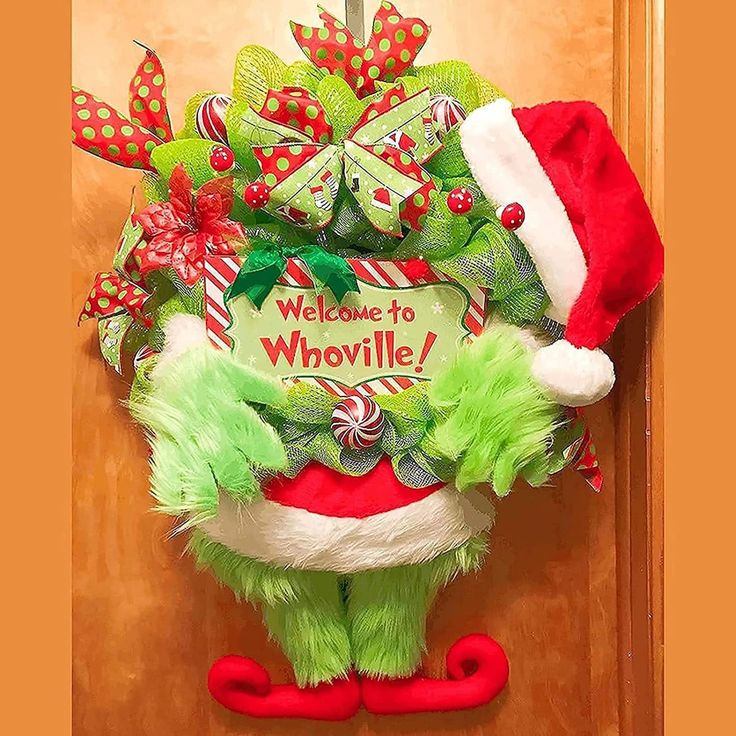 the grinch door hanger has been decorated with green and red christmas wreaths