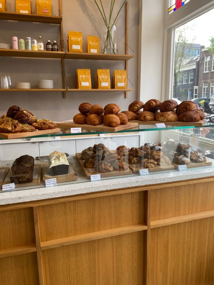 there are many different types of pastries on the counter in this bakery display case