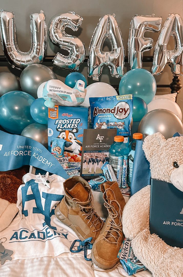 a teddy bear sitting on top of a bed next to some balloons and other items