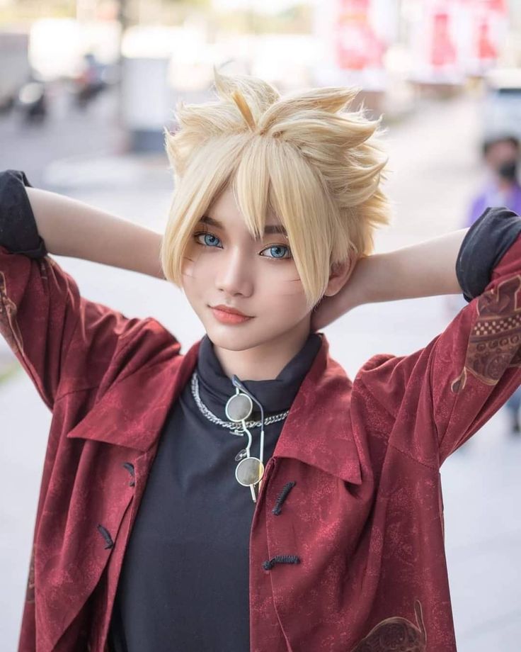 a woman with blonde hair and blue eyes wearing a red jacket is posing for the camera