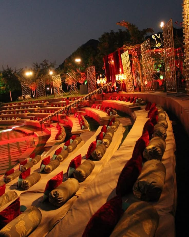 rows of seats are lined up on the side of a stage with lights in the background