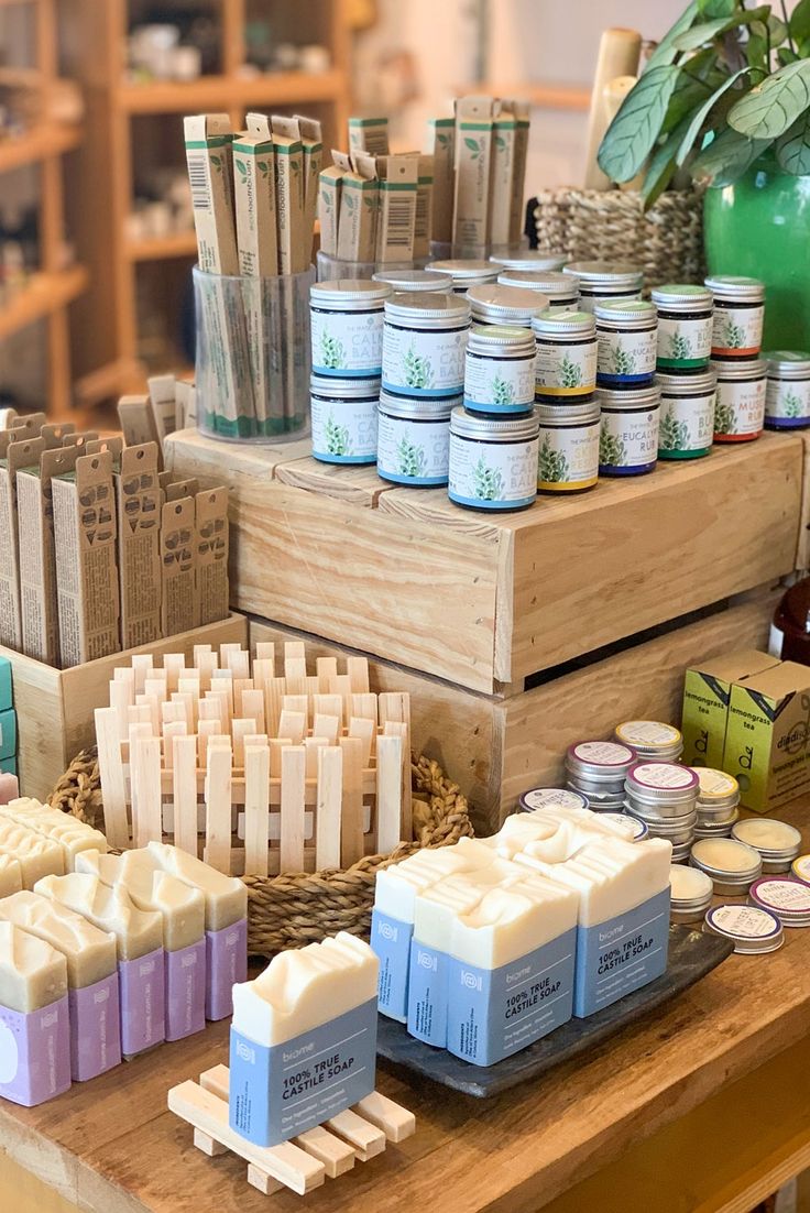 several different types of soaps and candles on a table in a store or shop