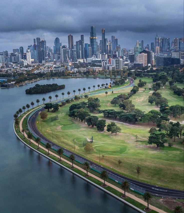 an aerial view of a city and the water with trees on both sides in front of it