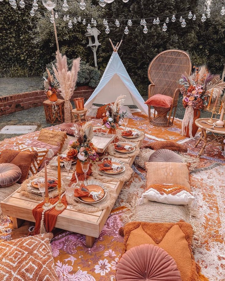 an outdoor table set up with orange and white decor for a dinner party or celebration