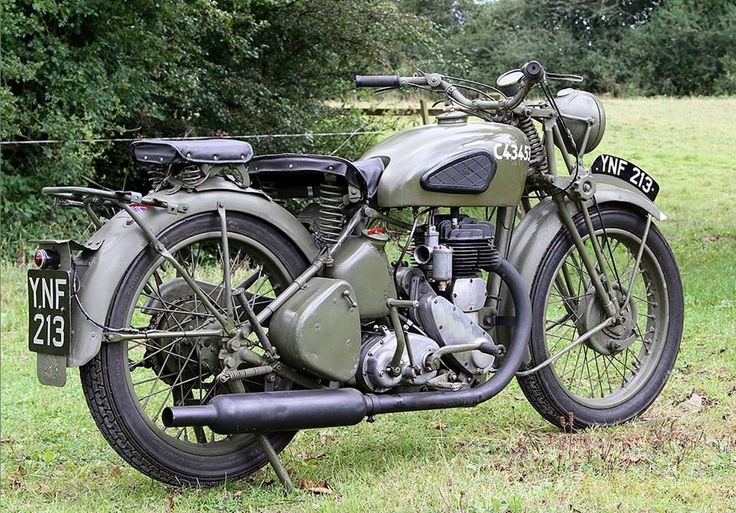 an old motorcycle is parked in the grass