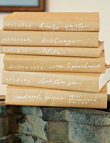 five brown paper bags with writing on them stacked up in front of each other,