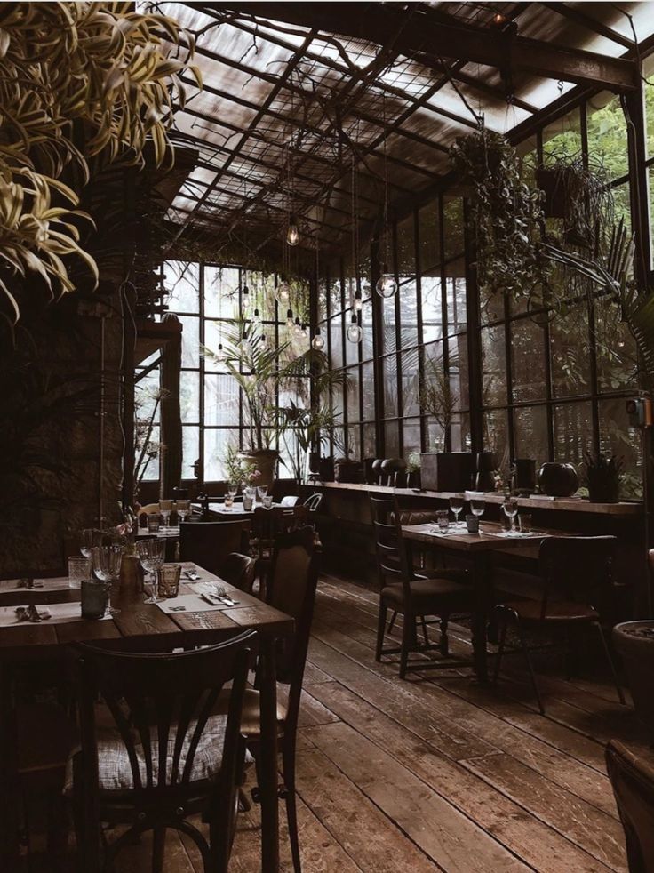 an empty restaurant with tables and chairs in front of large glass windows that look out onto the outdoors