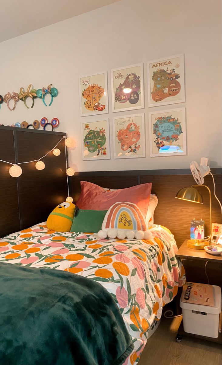 a bed room with a neatly made bed and lots of pictures on the wall above it