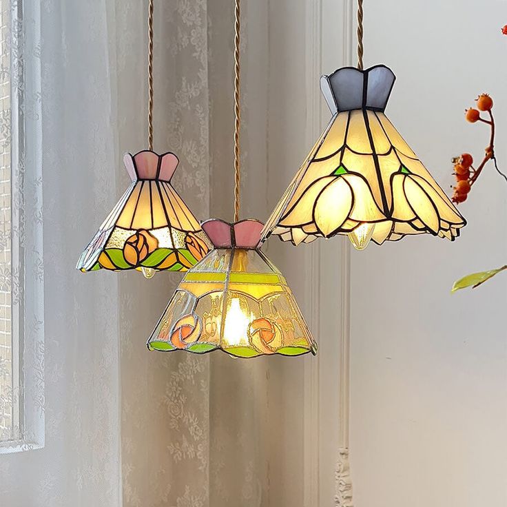 three stained glass lamps hanging from a ceiling