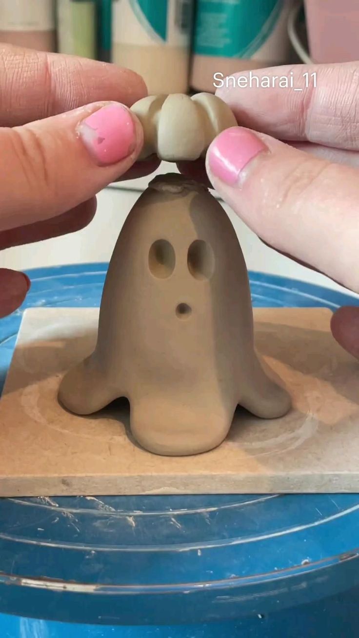 someone is making a fake ghost out of clay with their fingers and thumbnails