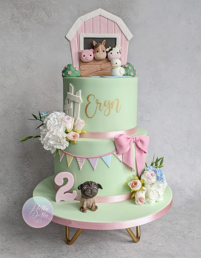 a three tiered cake with a dog on top and flowers around the edges, decorated in pastel colors