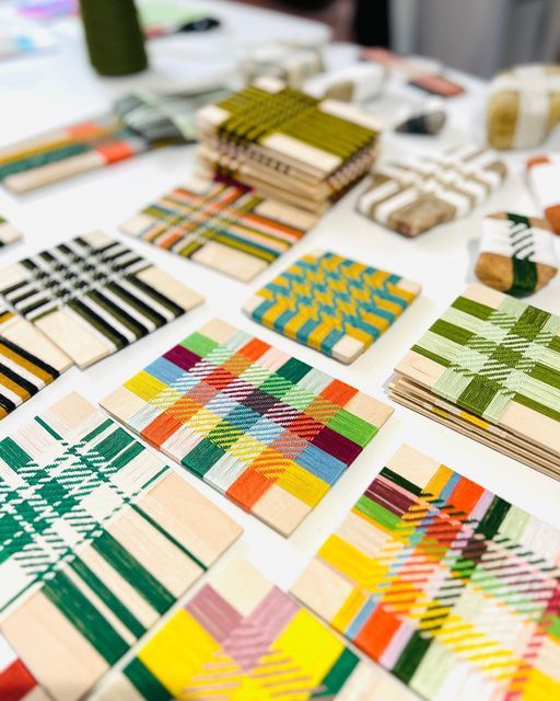 many different patterns and colors are laid out on a white table with some wood blocks