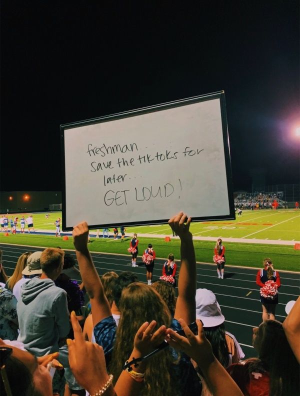 a group of people holding up signs at a football game