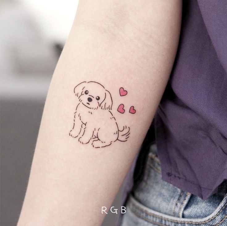 a small dog tattoo on the left upper arm and shoulder, with hearts coming out of it