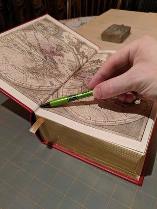 a person holding a pen and pointing at a map