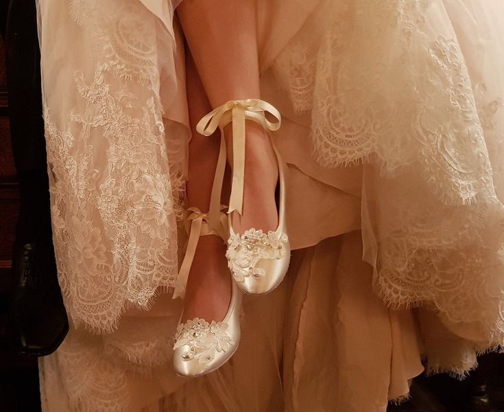 a woman is wearing white shoes with bows on the toes and laces around her ankles