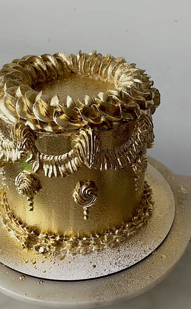 there is a gold cake on the plate and it looks like it has been decorated