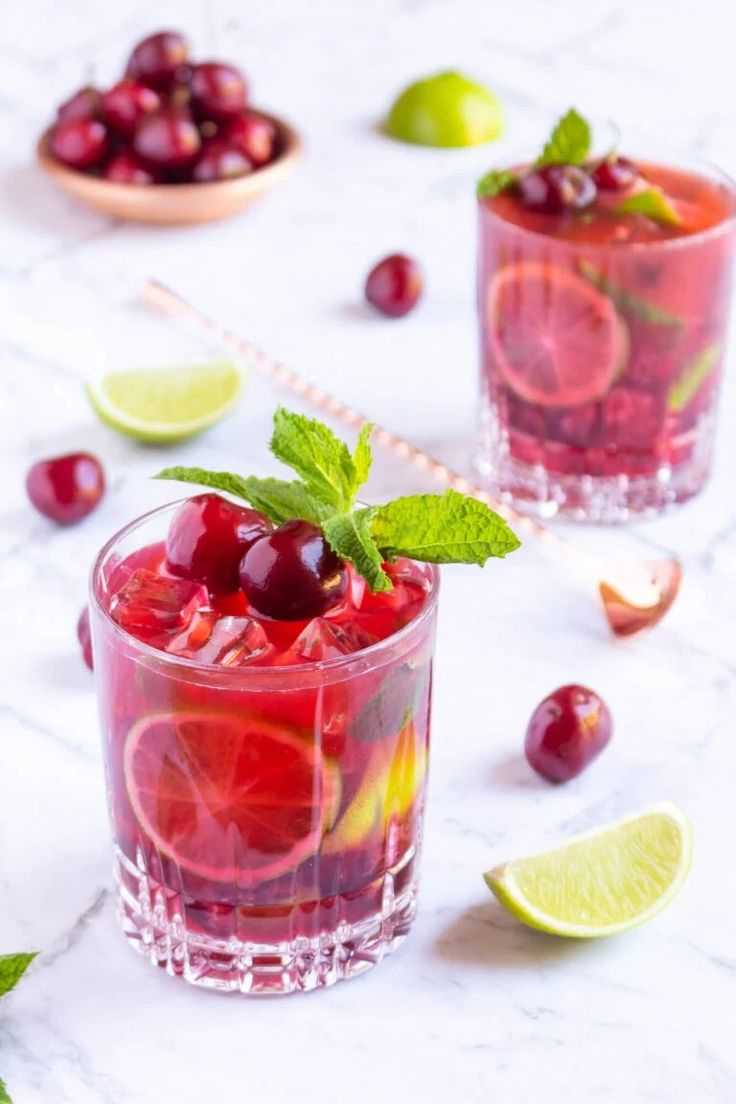 two glasses filled with cranberry and limeade cocktails on a marble table