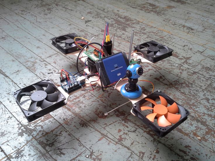 an electronic device sitting on top of a wooden floor next to cooling fans and wires