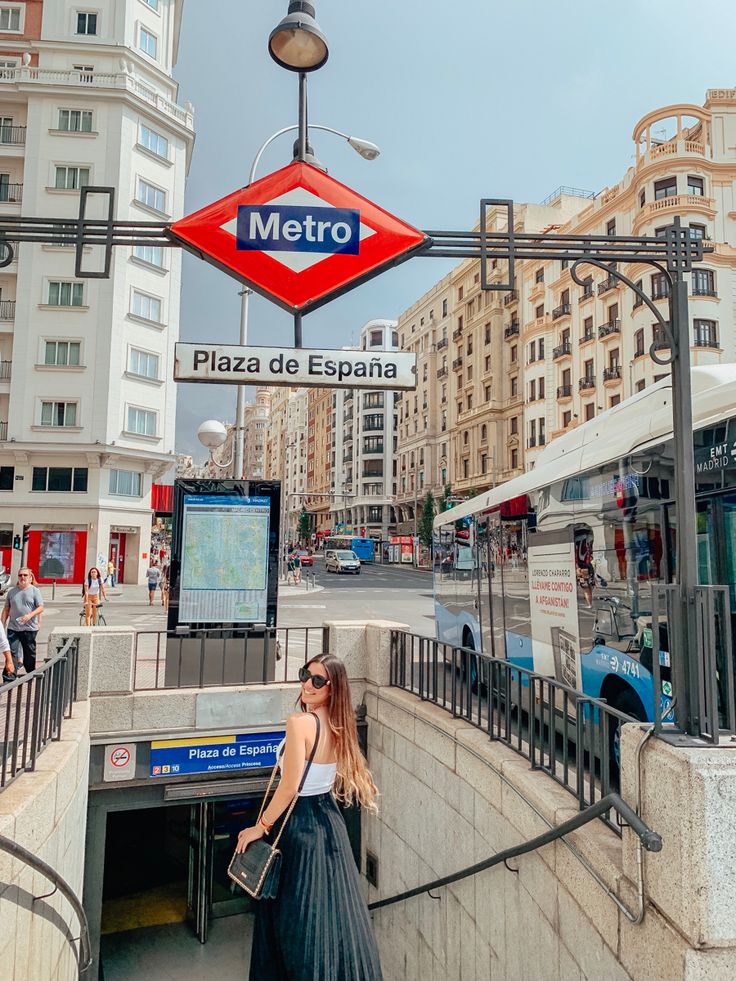 a woman standing in front of a metro station