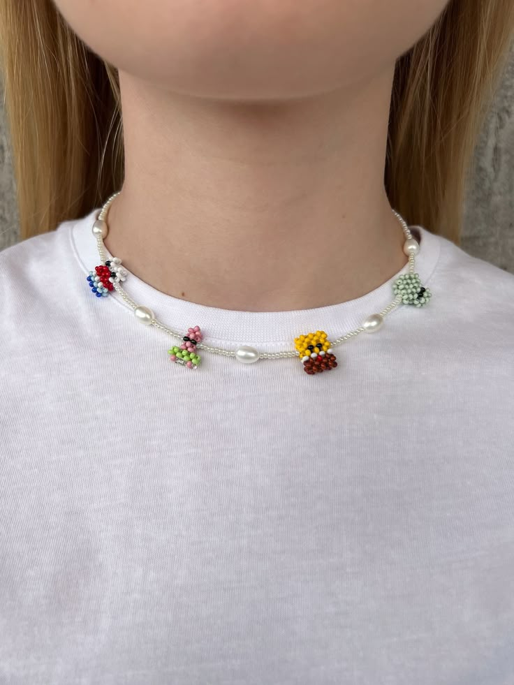 This whimsical SpongeBob beaded necklace is an ideal accessory for fans of the show looking to add a playful touch to their outfit. Crafted from handmade glass beads shaped like SpongeBob SquarePants characters -- Patrick, Squidward, Mr. Krabs, and SpongeBob himself -- the necklace also includes natural freshwater pearl beads for an elegant flair. The rhodium-plated clasp ensures the necklace remains untarnished over time, making it a durable and lasting piece. Product Details:  * Material: Hand Fun Beaded Necklaces For Gifts, Necklace Handmade Ideas, Handmade Playful Beaded Necklaces For Jewelry Making, Whimsical Beaded Necklaces For Party, White Letter Beads Necklace For Party, Whimsical Party Beaded Necklaces, Playful White Beaded Chain Jewelry, Playful White Beaded Chain Necklace, Playful White Handmade Necklace