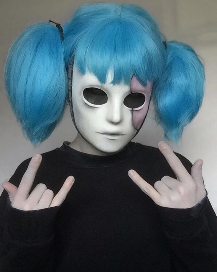 a person with blue hair wearing a white mask and making the peace sign in front of their face